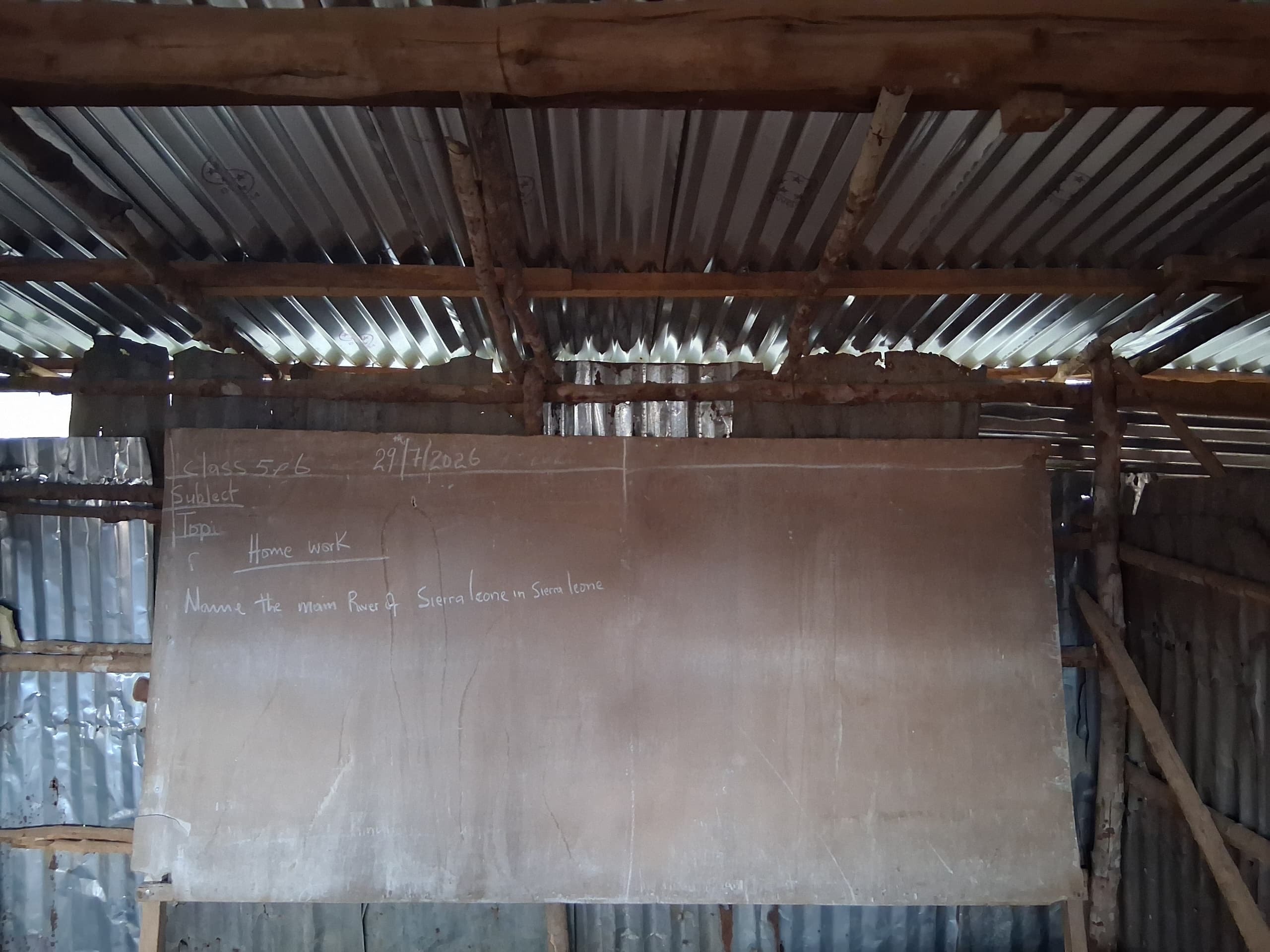 Classroom board showing a geography homework assignment for Class 5 and 6 — naming the main rivers of Sierra Leone
